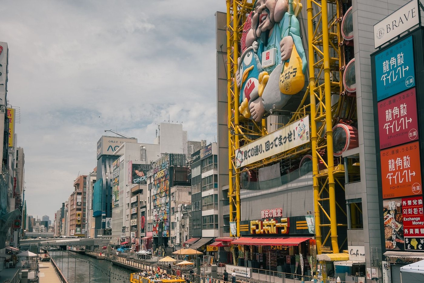 The Dotonbori Glico runner sign lit at night above the canal, surrounded by other illuminated signs