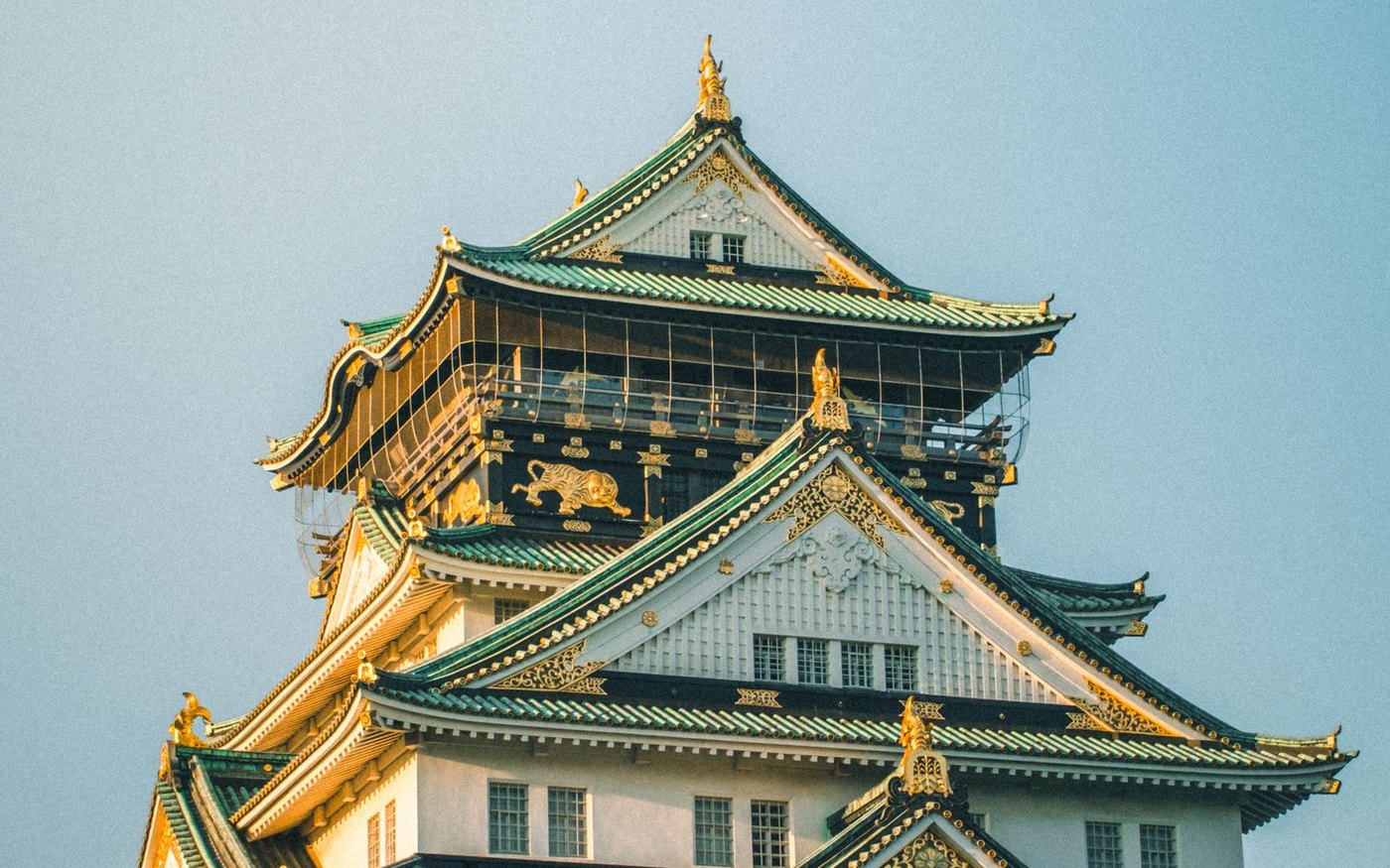 Osaka Castle's main tower in daylight, surrounded by trees